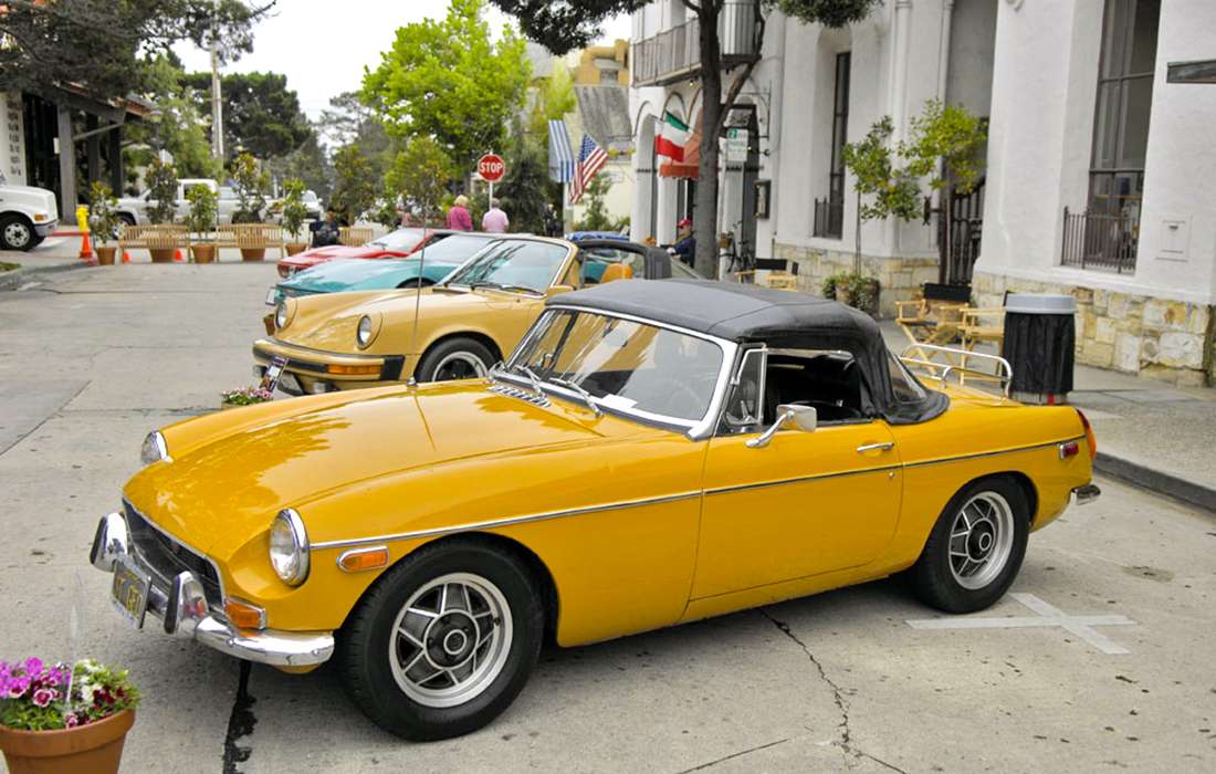 Plusieurs anciennes voitures jaune dans une rue
