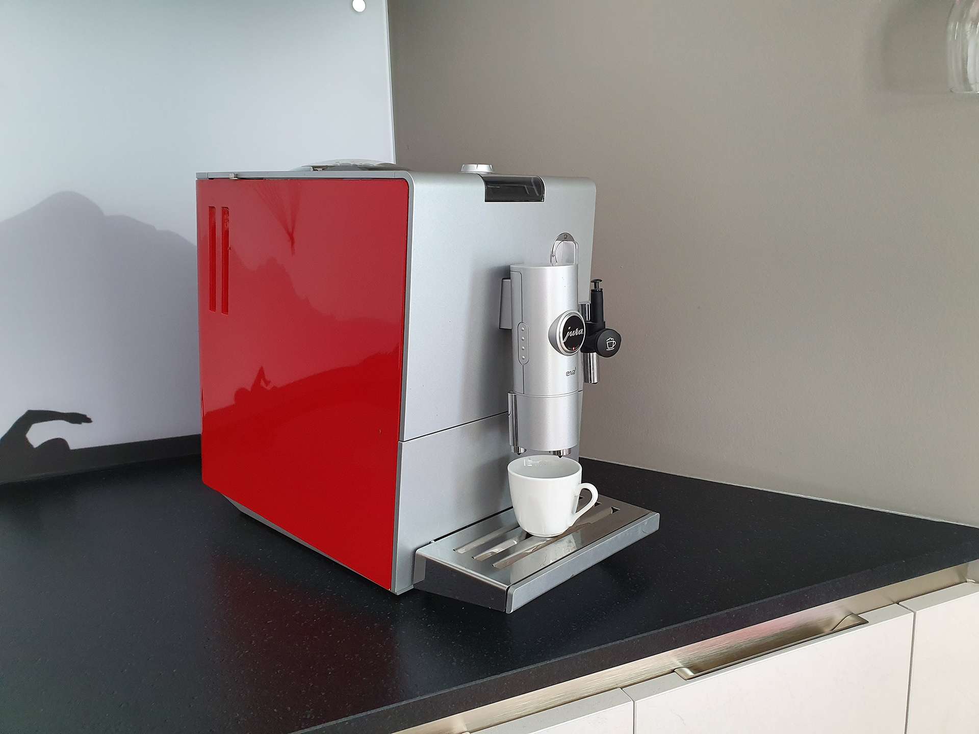 Cafetière rouge et grise avec une tasse de café