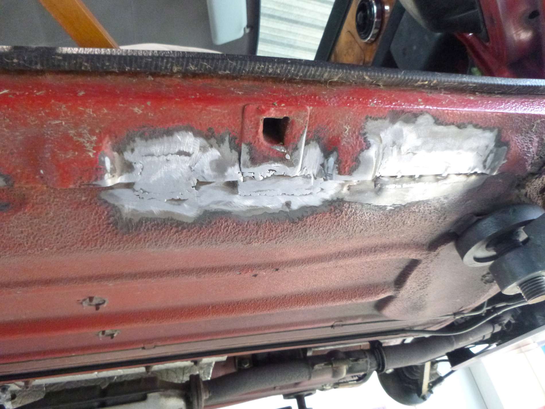 Traitement antirouille sur le dessous d'une voiture rouge