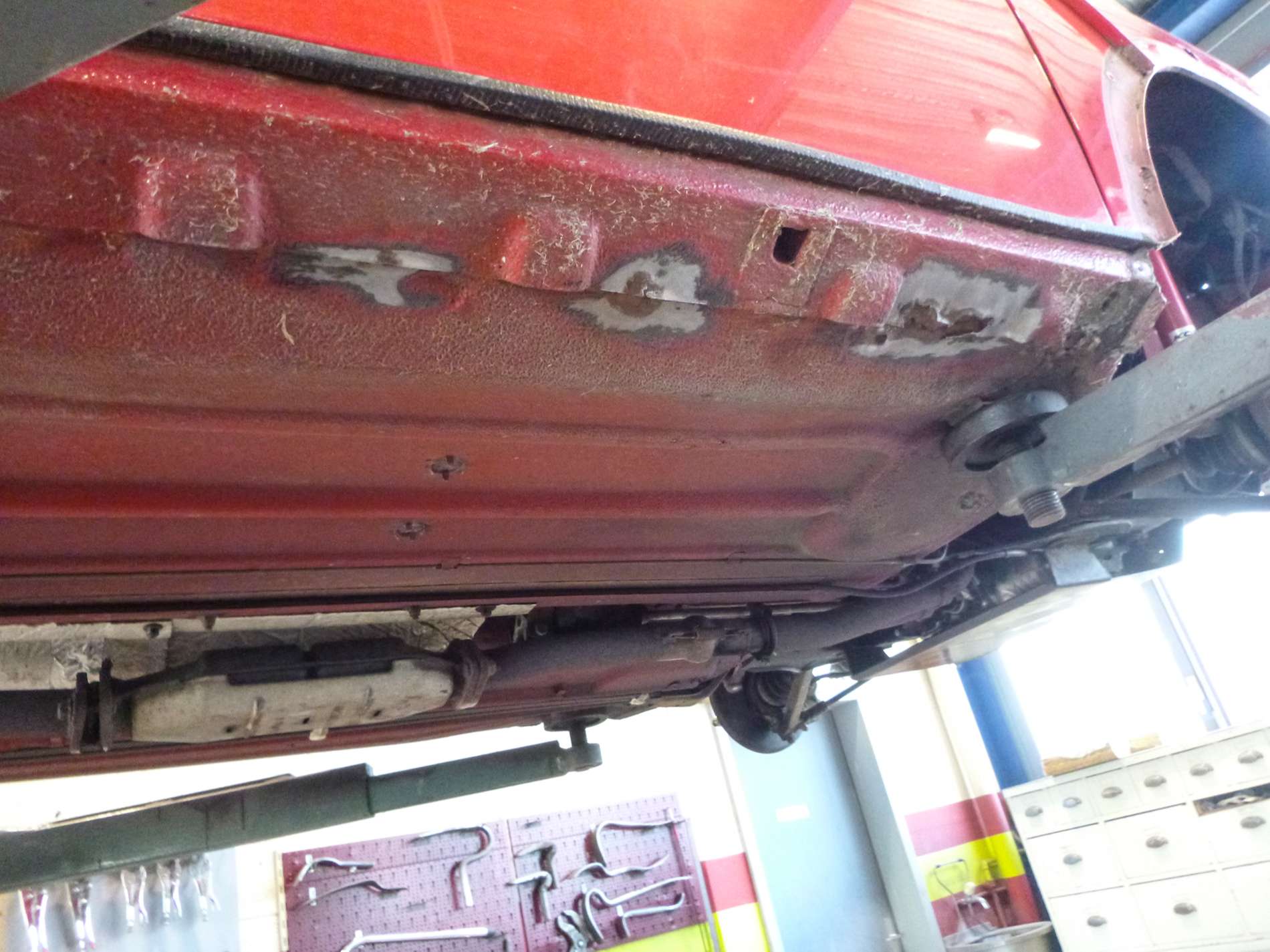 Traitement antirouille sur le dessous d'une voiture rouge