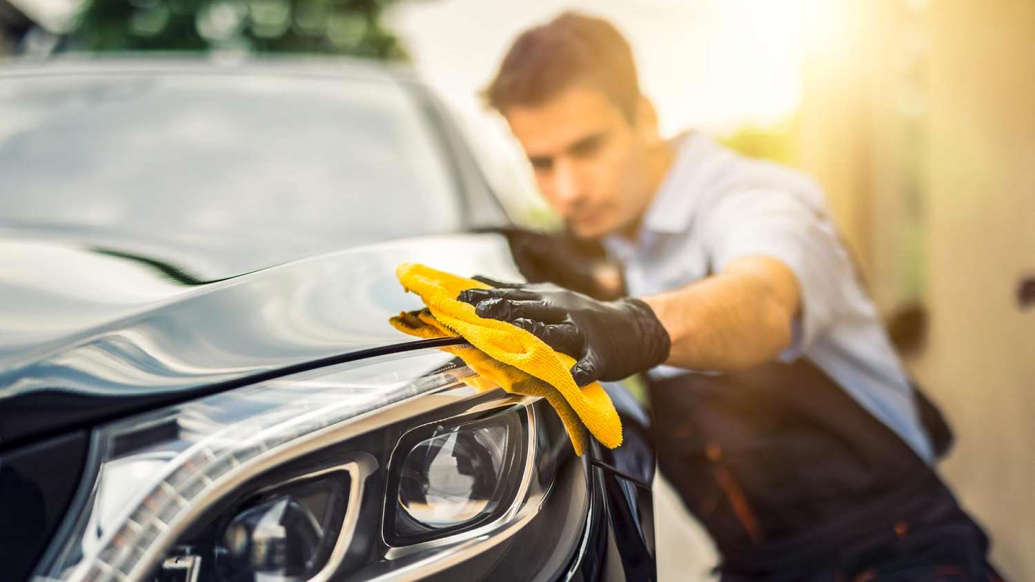 Un homme qui applique un traitement céramique sur une voiture