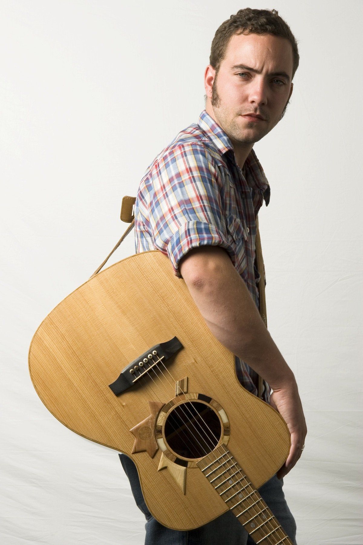 Portrait of Justin Rutledge with Voyageur slung over his shoulder at the Edmonton Folk Festival, August