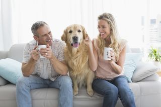 couple on couch with dog while drinking from mug
