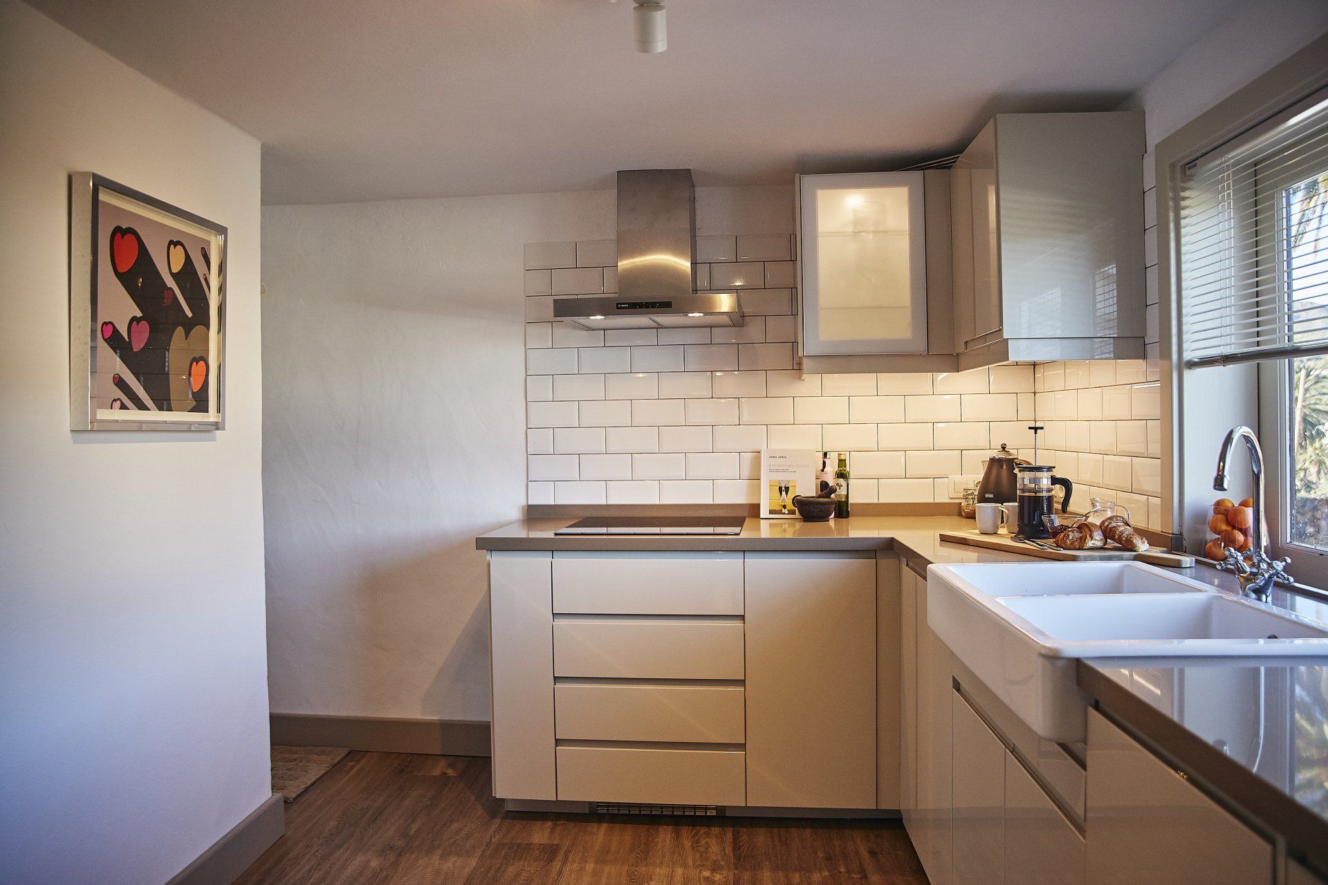 A kitchen with white cabinets , a sink and a stove.