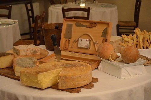 un tavolo con sopra dei formaggi e dei grissini