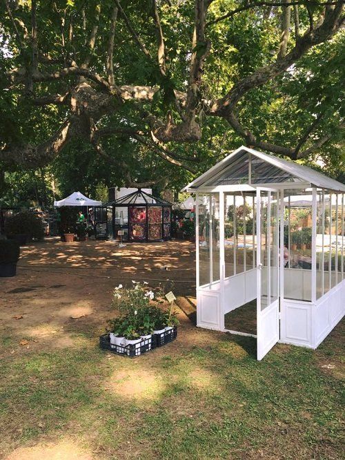 dei vasi con dei fiori e una piccola veranda bianca con un tetto