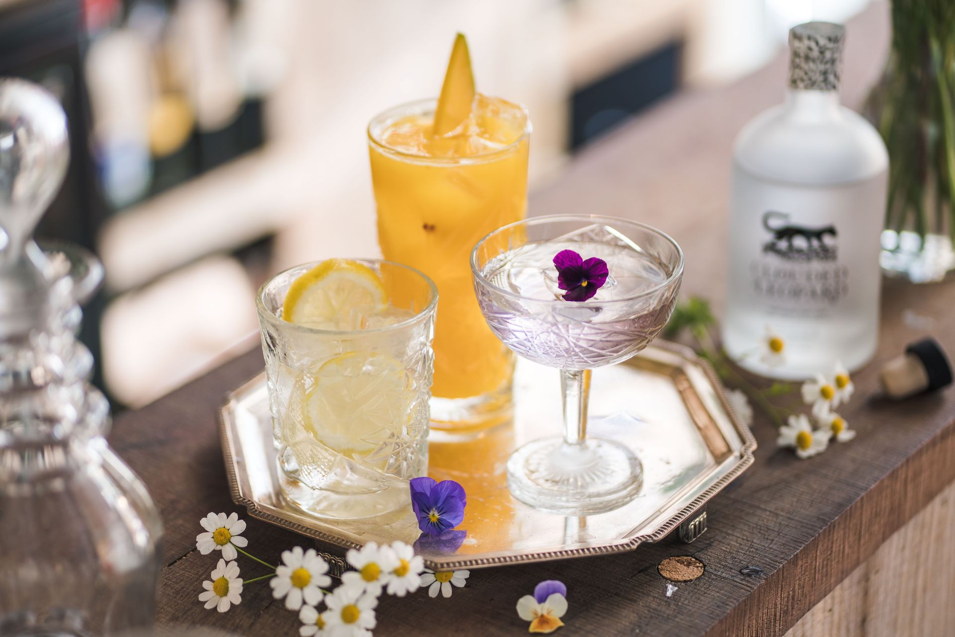 A bottle of vodka sits next to a tray of drinks