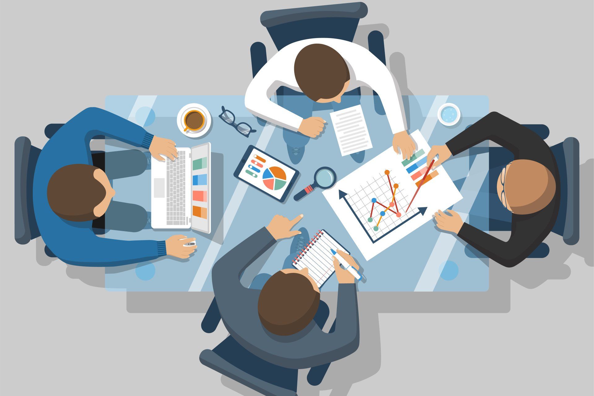 A group of people are sitting around a table with papers and a laptop