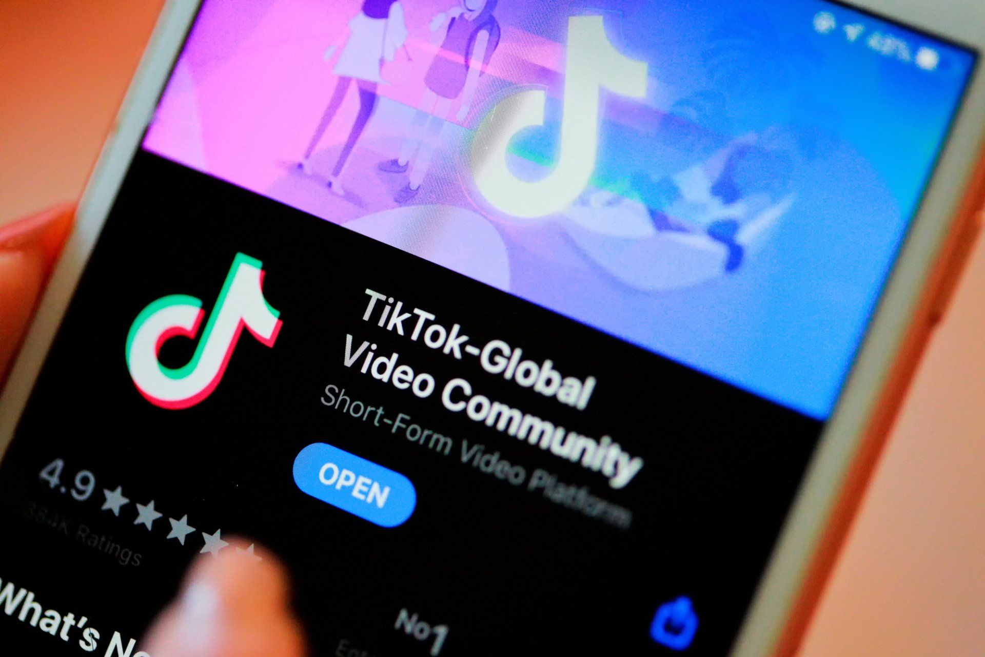 A person is holding a cell phone open to the tiktok global video community app