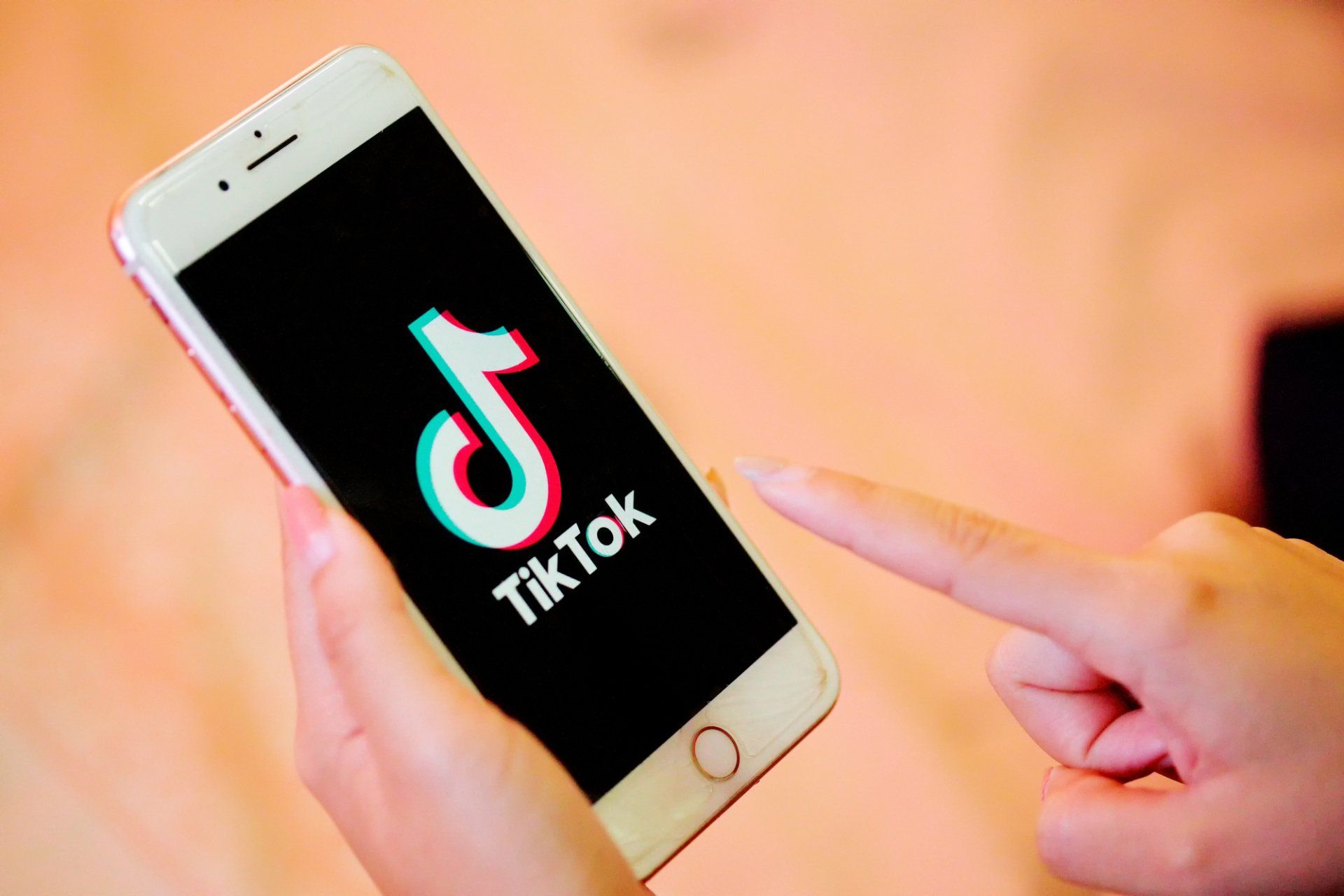 A person is holding a cell phone with the tik tok app on it.