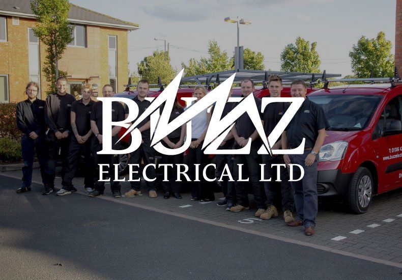 A group of men standing in front of buzz electrical ltd vans