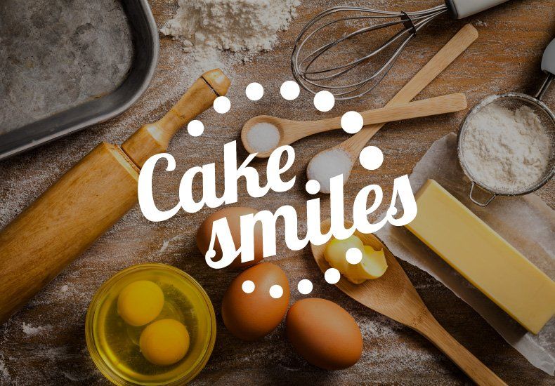 Cake smiles is written on a table with baking supplies