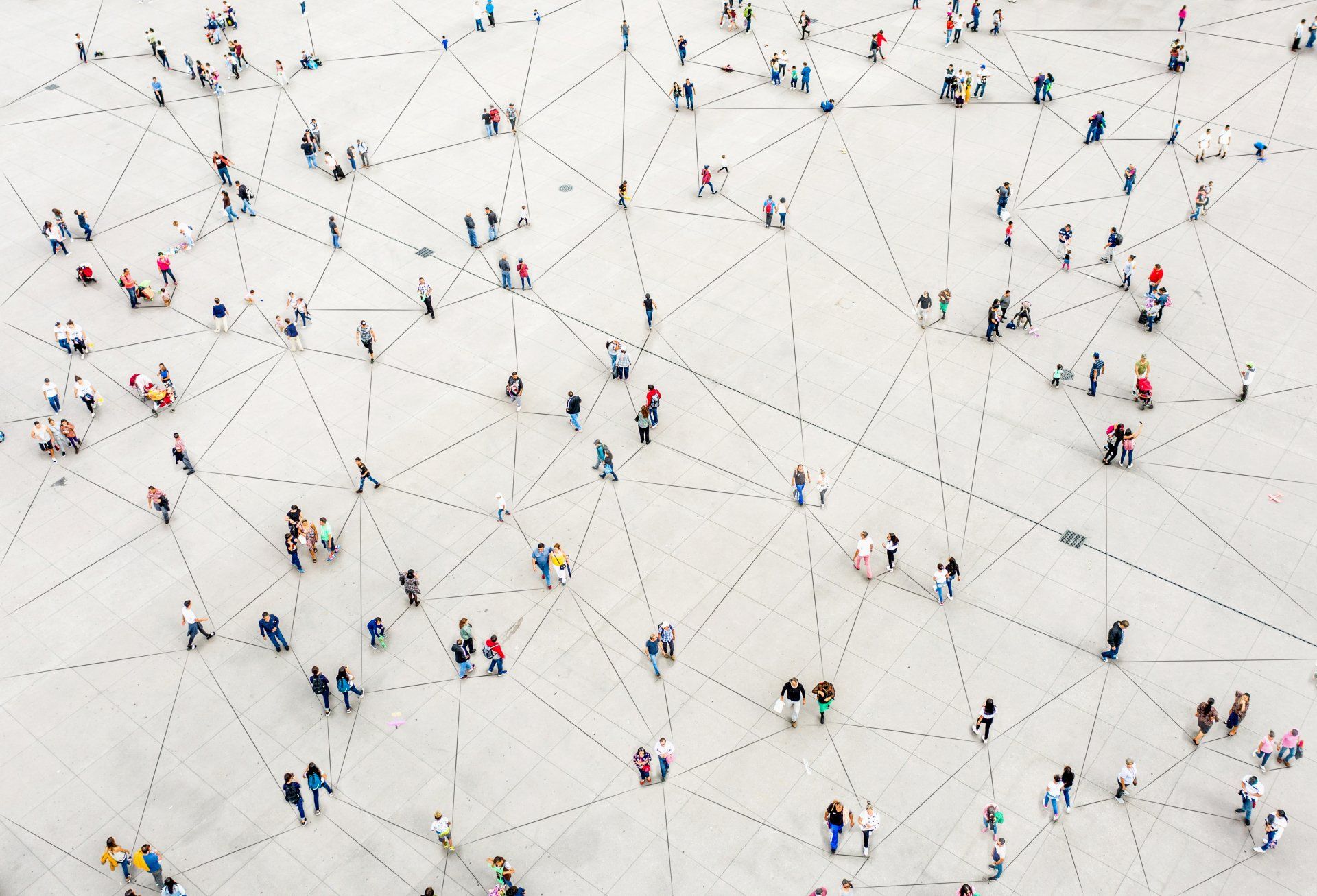 A large group of people are walking on a white surface