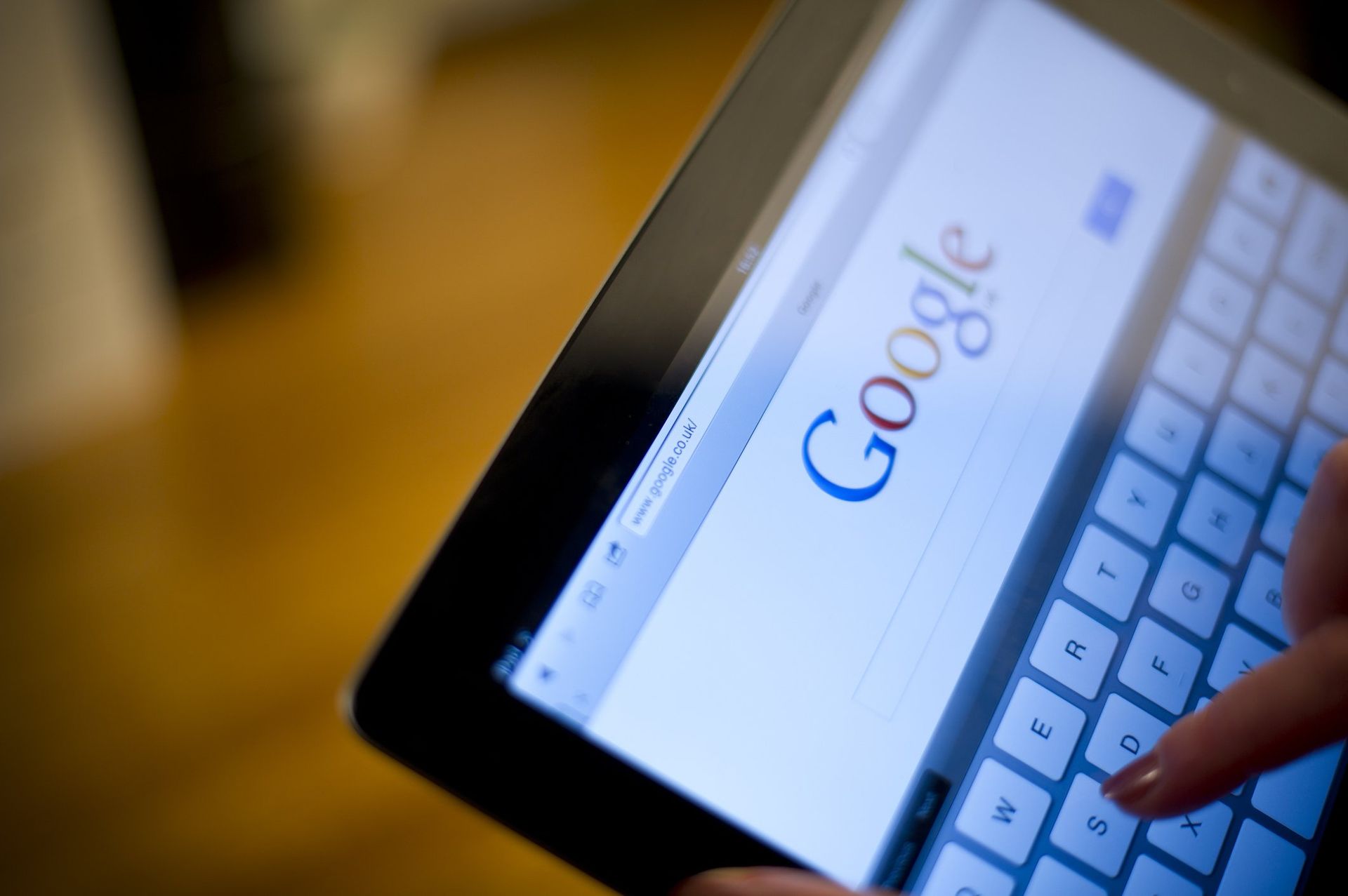 A person is using a tablet to search for google
