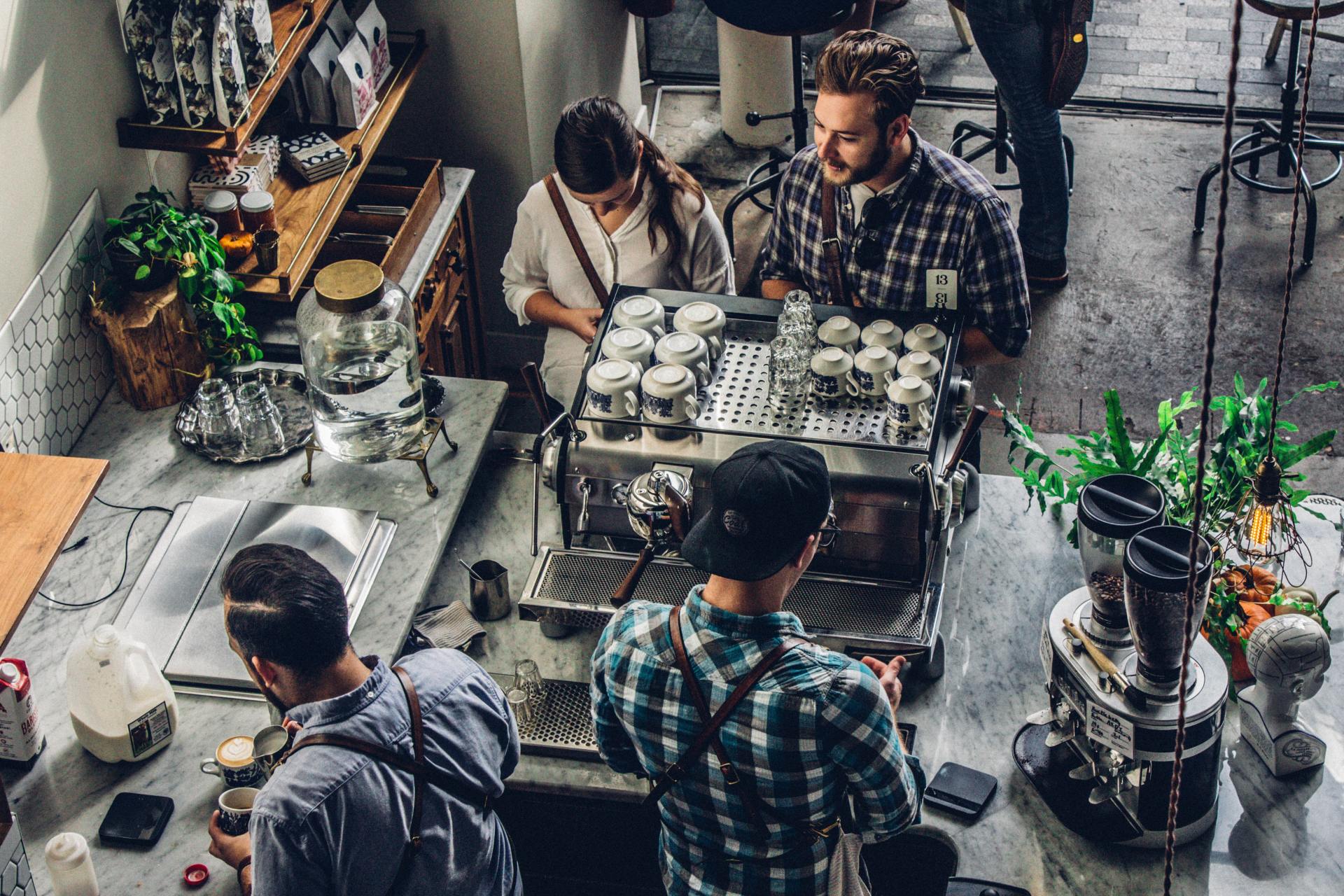 A group of people are sitting at a counter in a coffee shop