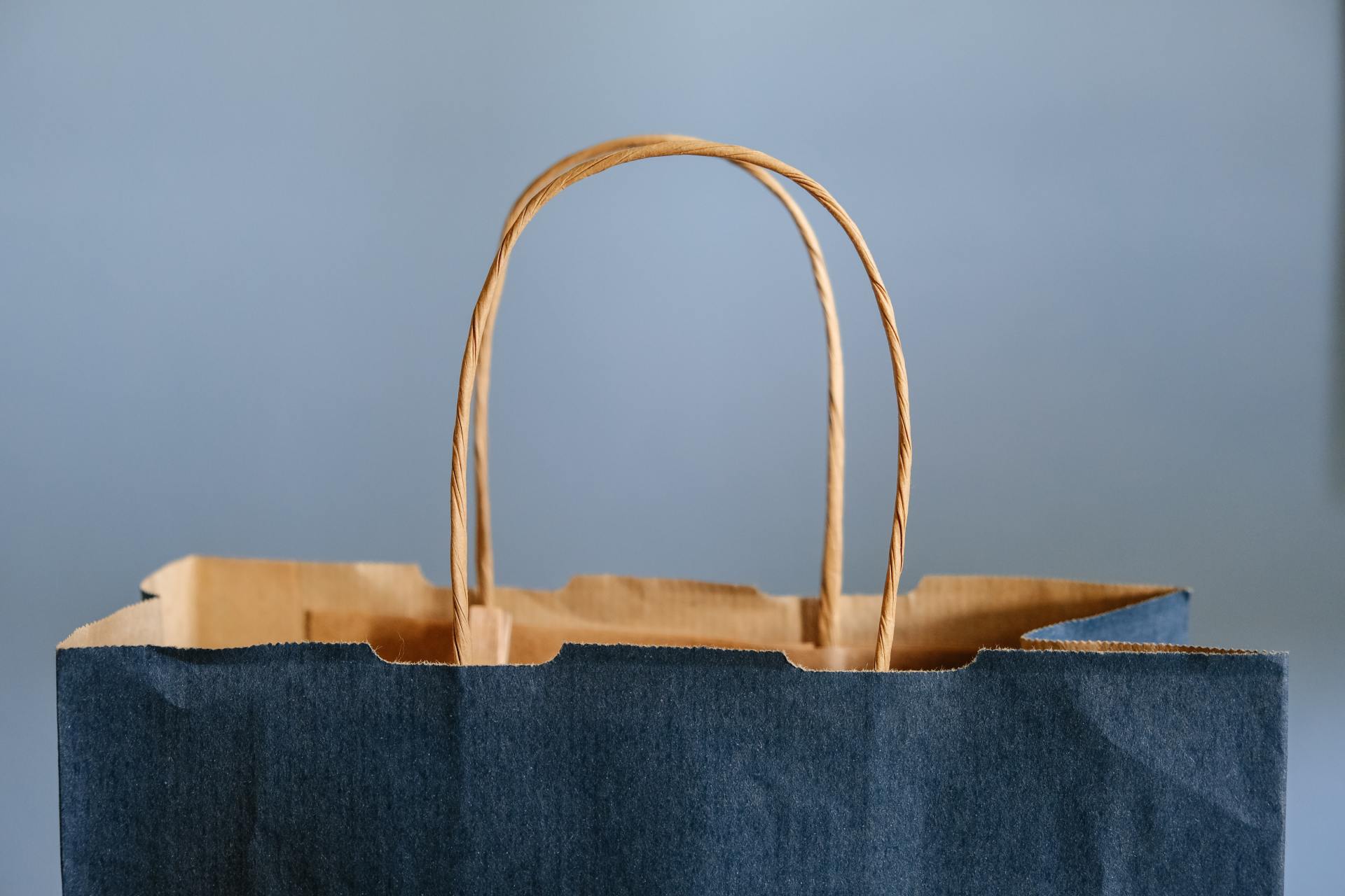 A black paper bag with a brown handle