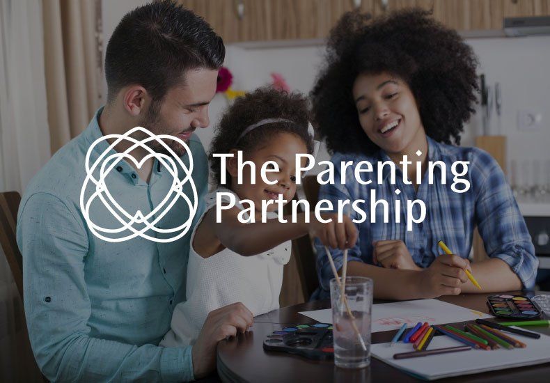 A family is sitting at a table with the parenting partnership logo