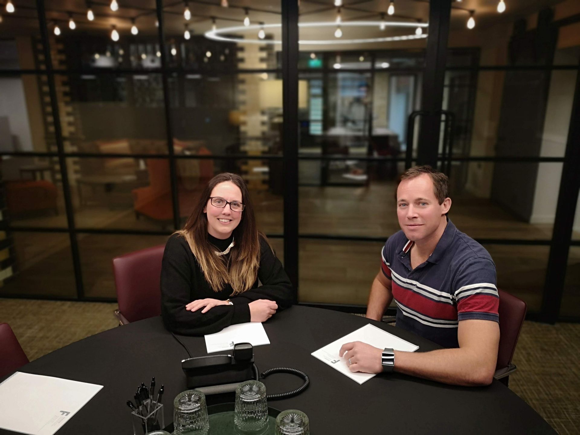 A man and a woman sit at a table with papers on it