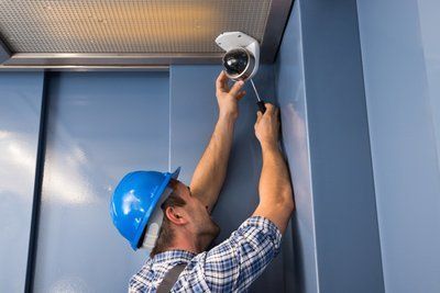 Operaio che installa videocamera di sorveglianza