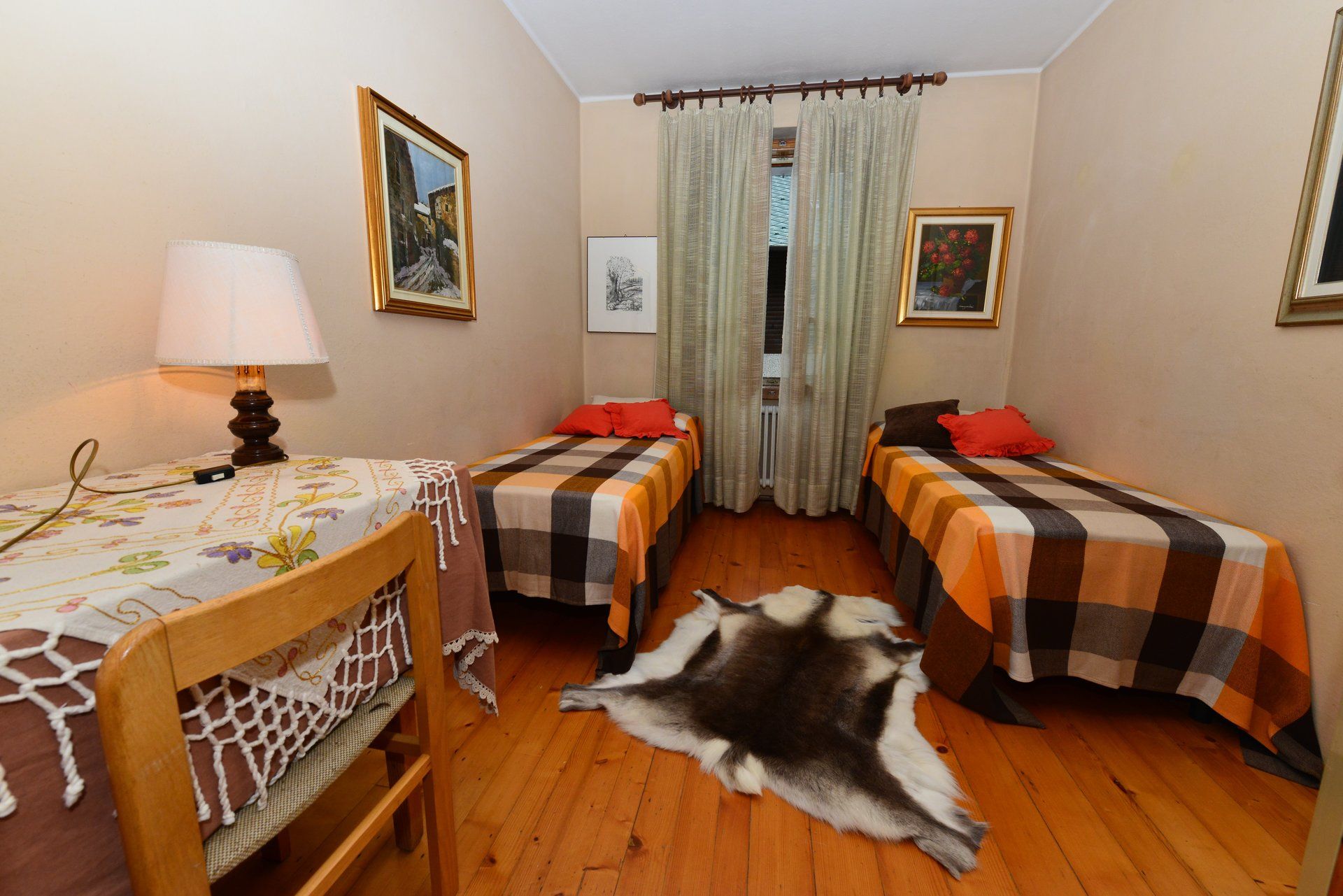 Una camera da letto con due letti un tavolo e una lampada