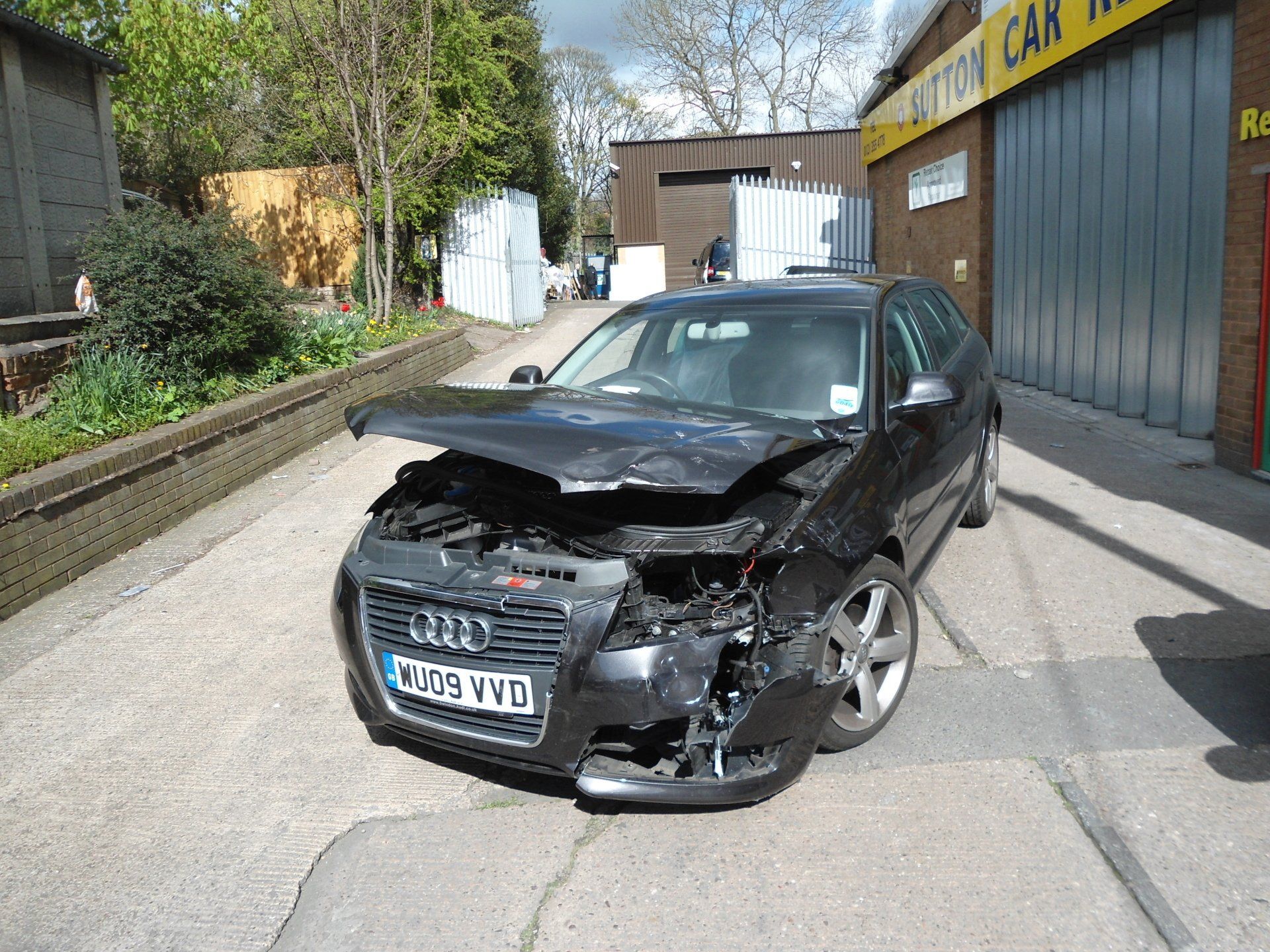 Mechanics checking damaged automobile