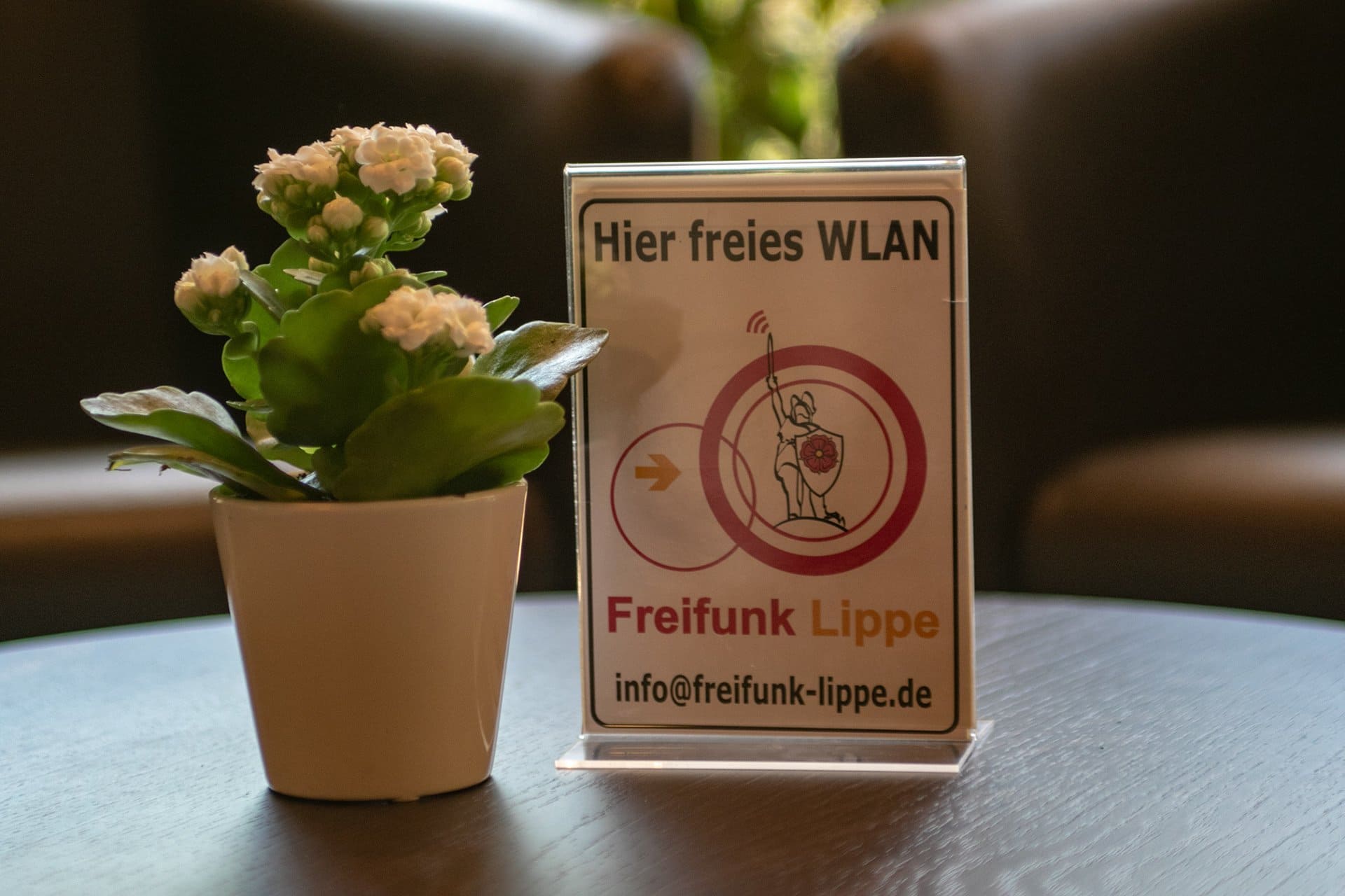 Ein Schild auf einem Tisch mit der Aufschrift „Hier kostenloses WLAN“