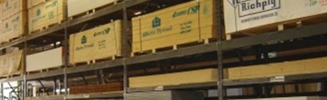 Shelves in a warehouse filled with wooden boxes and long panels.