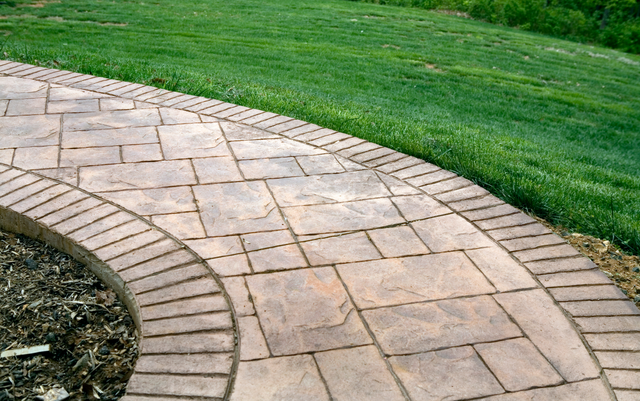 Stamped concrete walkway in a residential backyard.