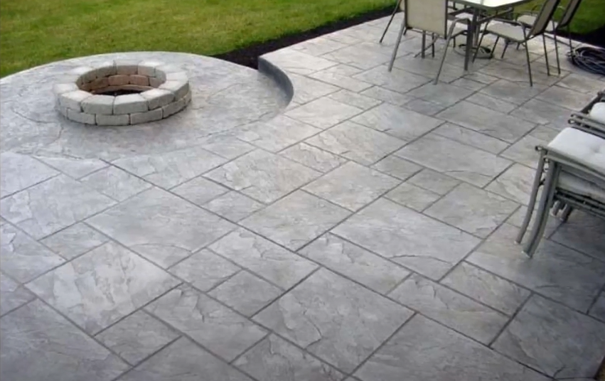 Picture of a concrete patio with a fireplace built in.