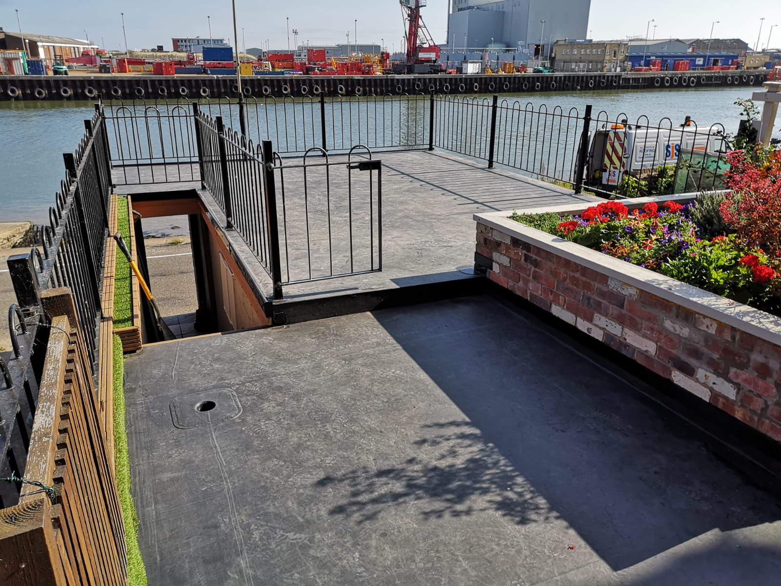 a fenced in area with a dock in the background