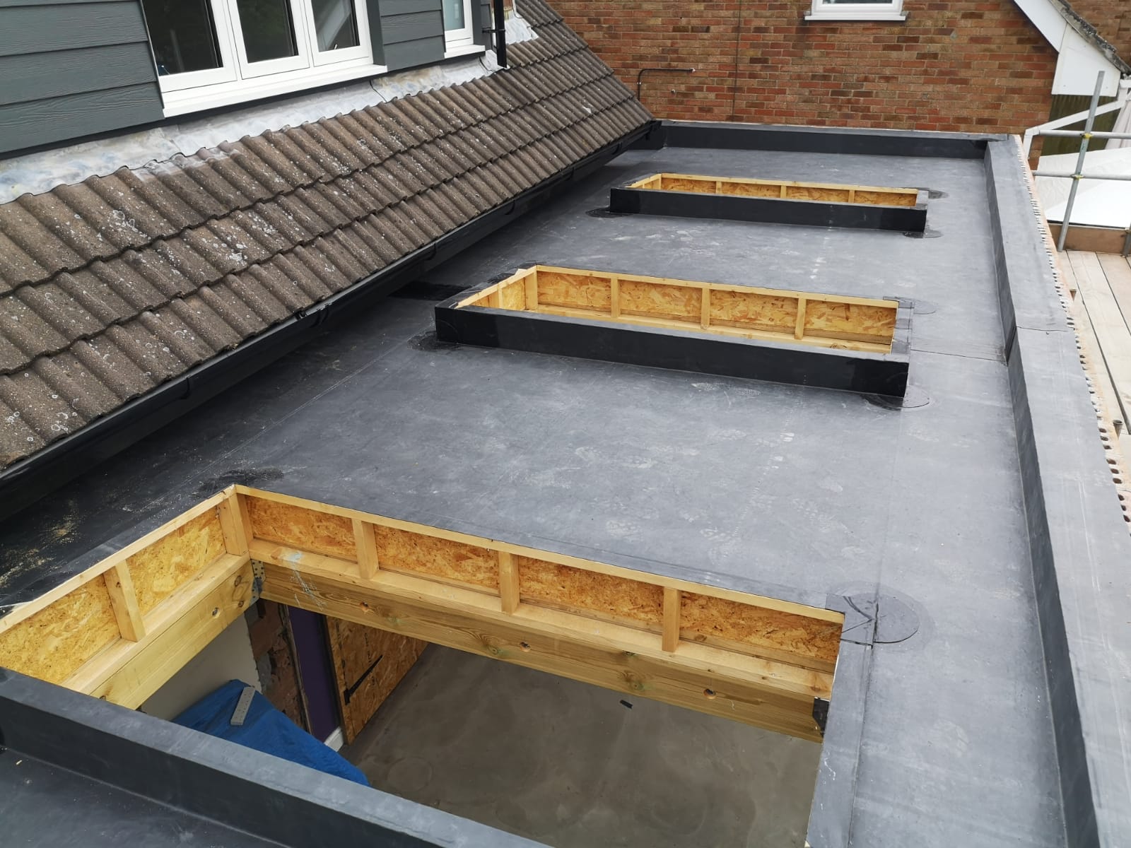 the roof of a house is being remodeled with a black roof