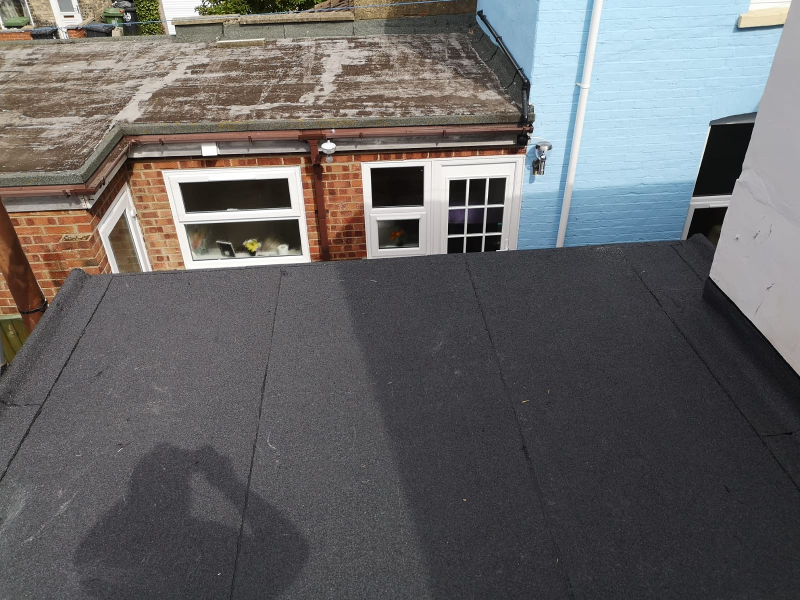 a blue house with a black roof and a white door