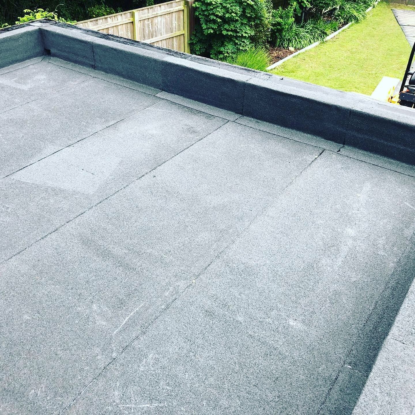a black roof with a wooden fence in the background