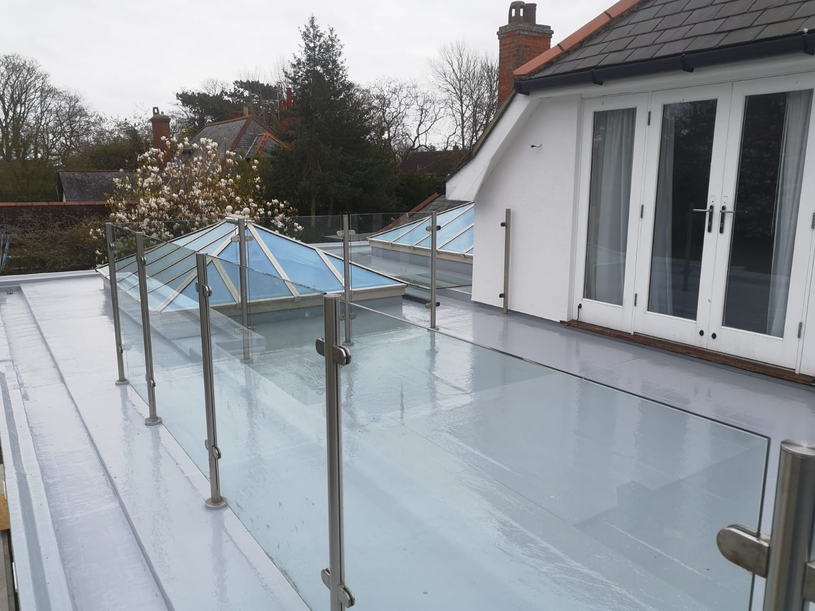 a balcony with a glass railing and a skylight