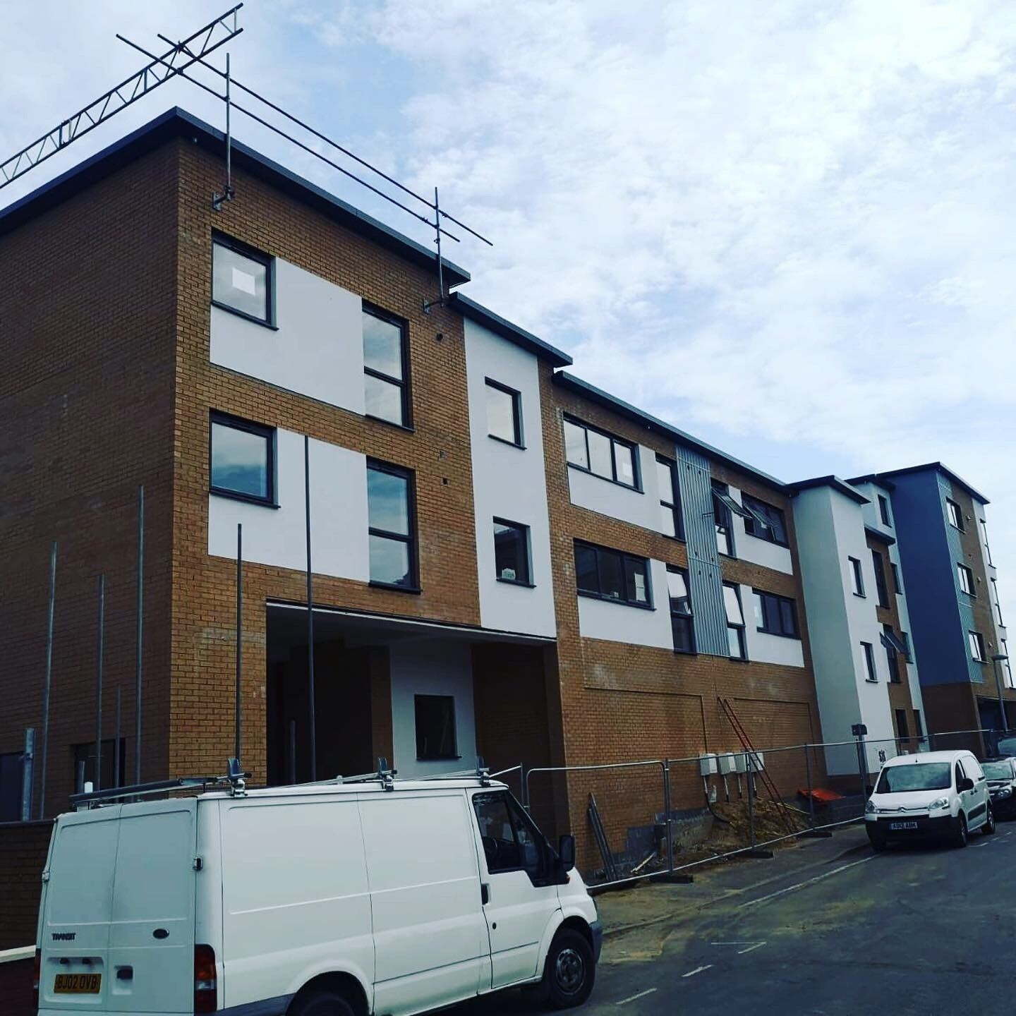 a white van is parked in front of a building under construction