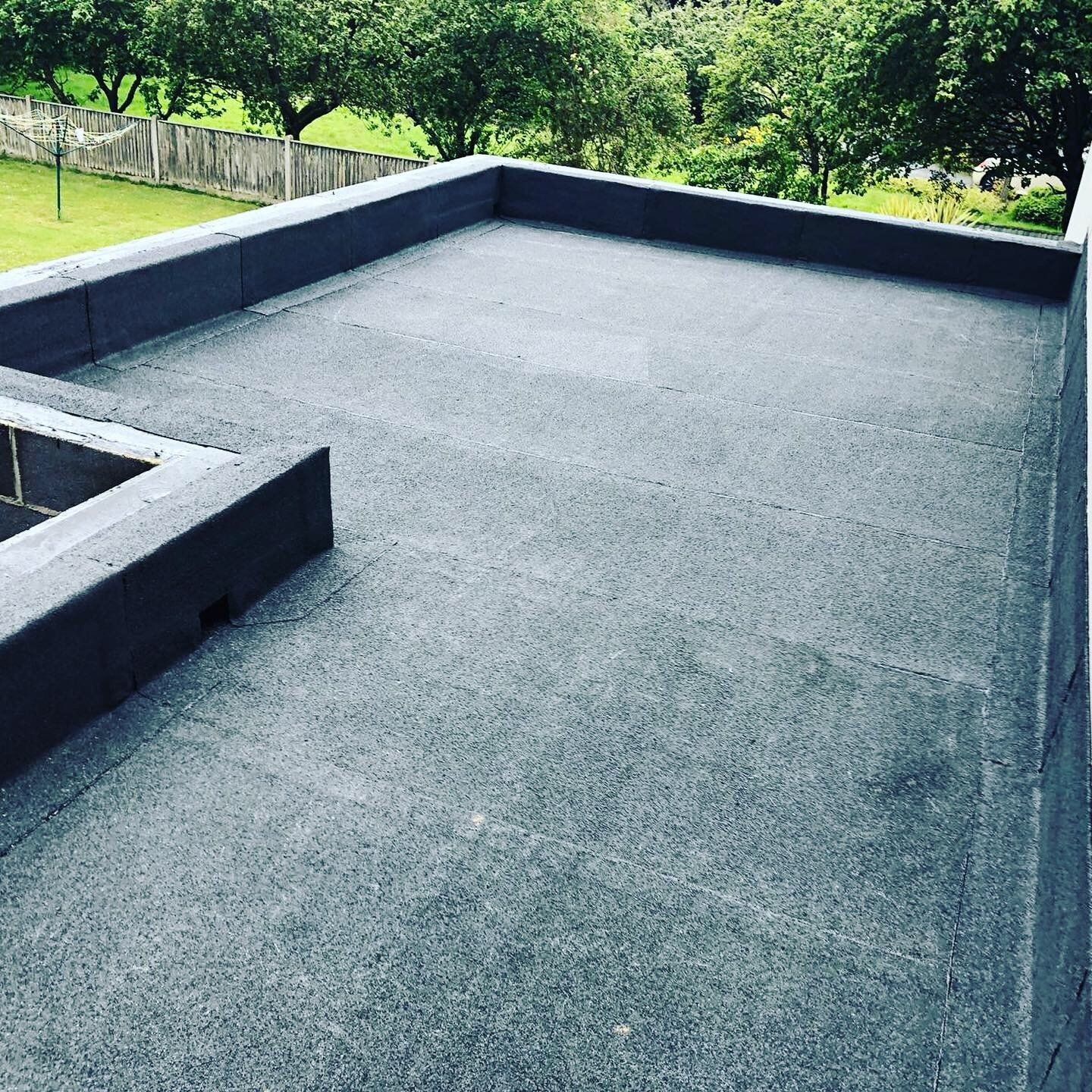 a black roof with a fence in the background