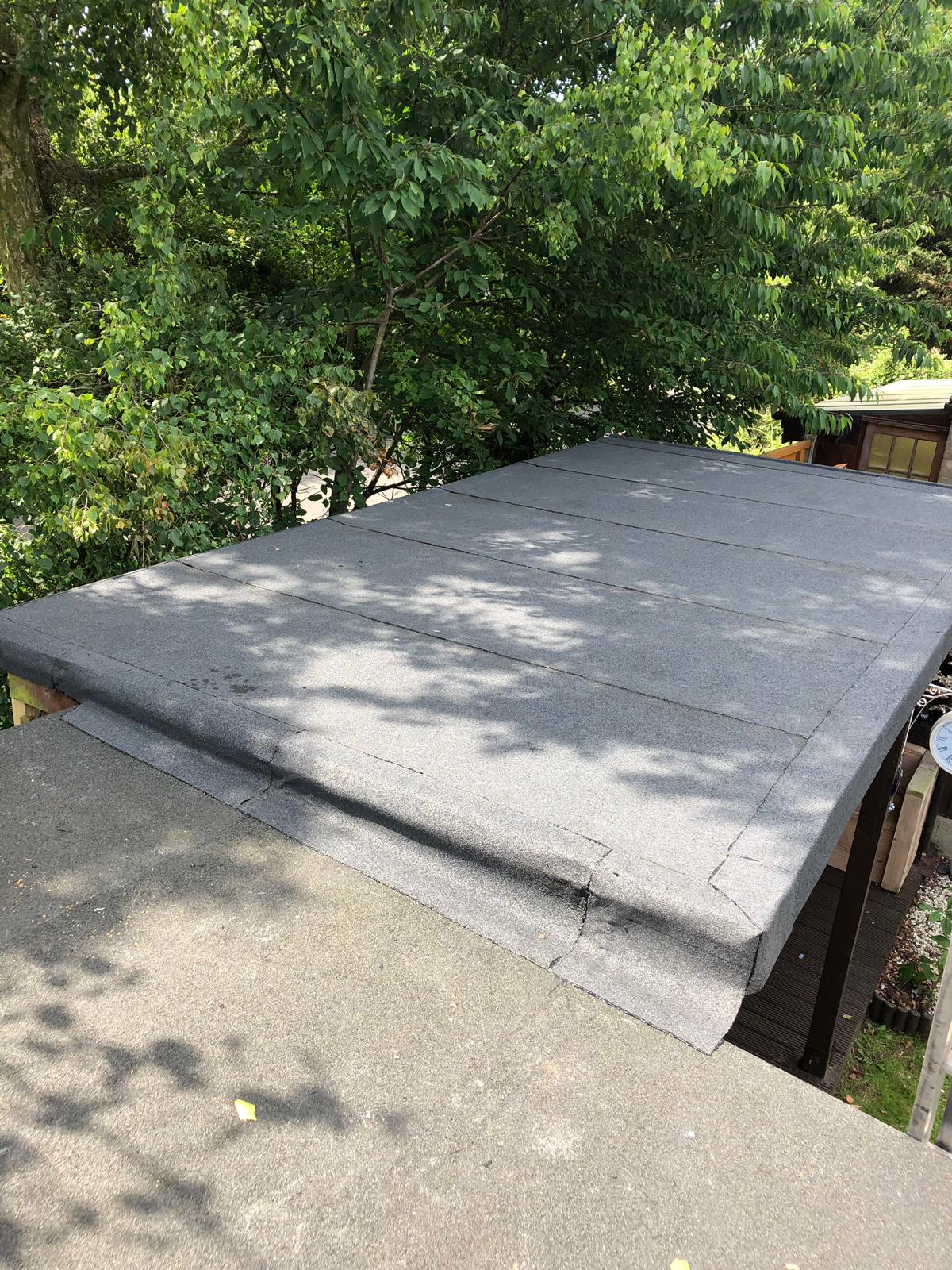 a roof with a few trees in the background