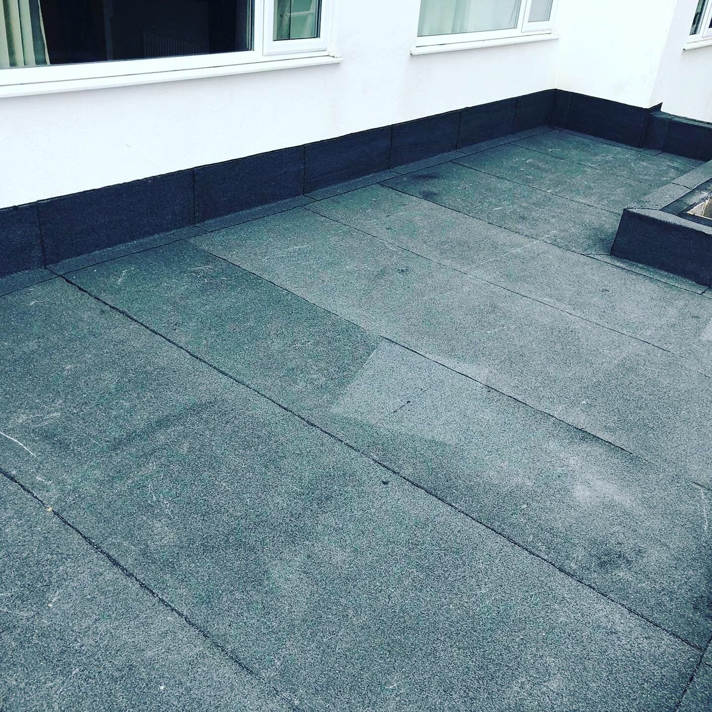 a gray tile floor with a window in the background