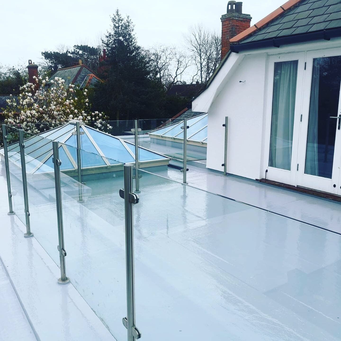 a balcony with a stainless steel railing and a skylight