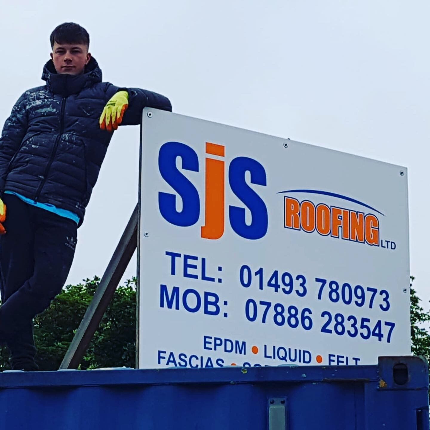 a man leans against a sign that says sjs roofing