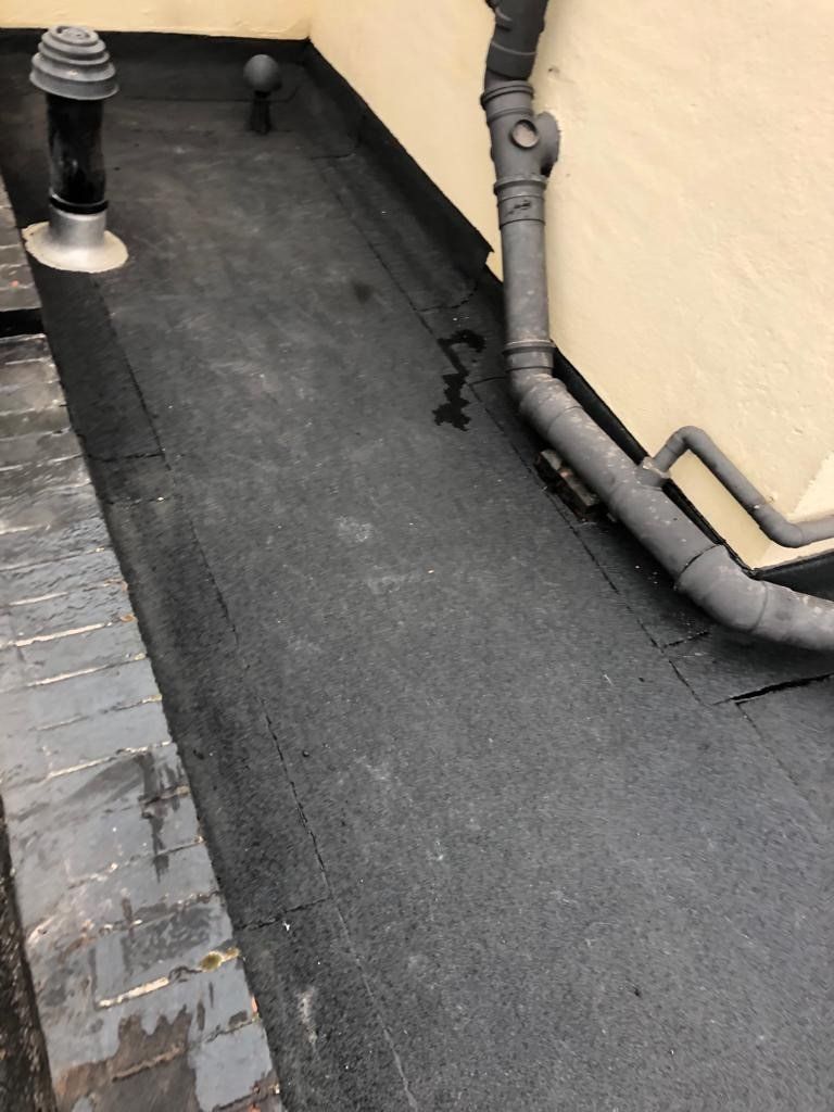 a pipe on the side of a building next to a chimney