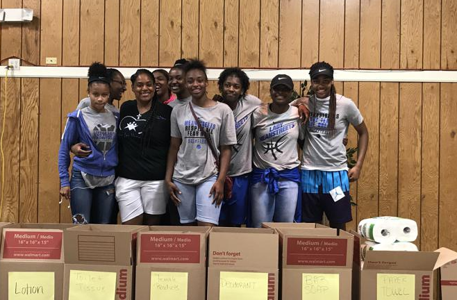 A group of people are posing for a picture in front of boxes.