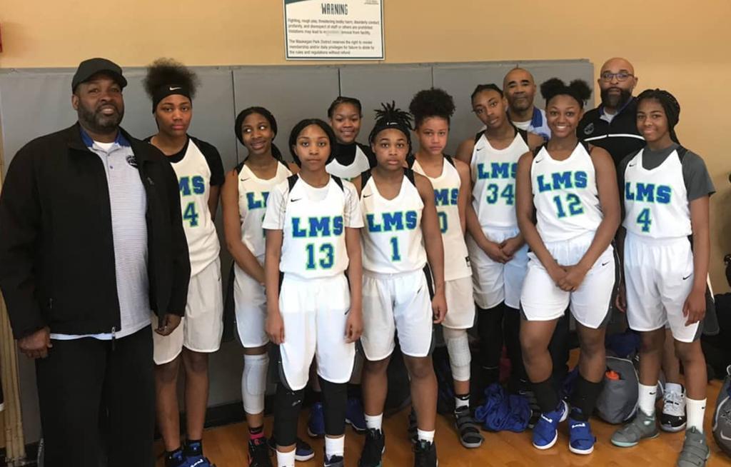 A group of basketball players are posing for a picture with their coaches.