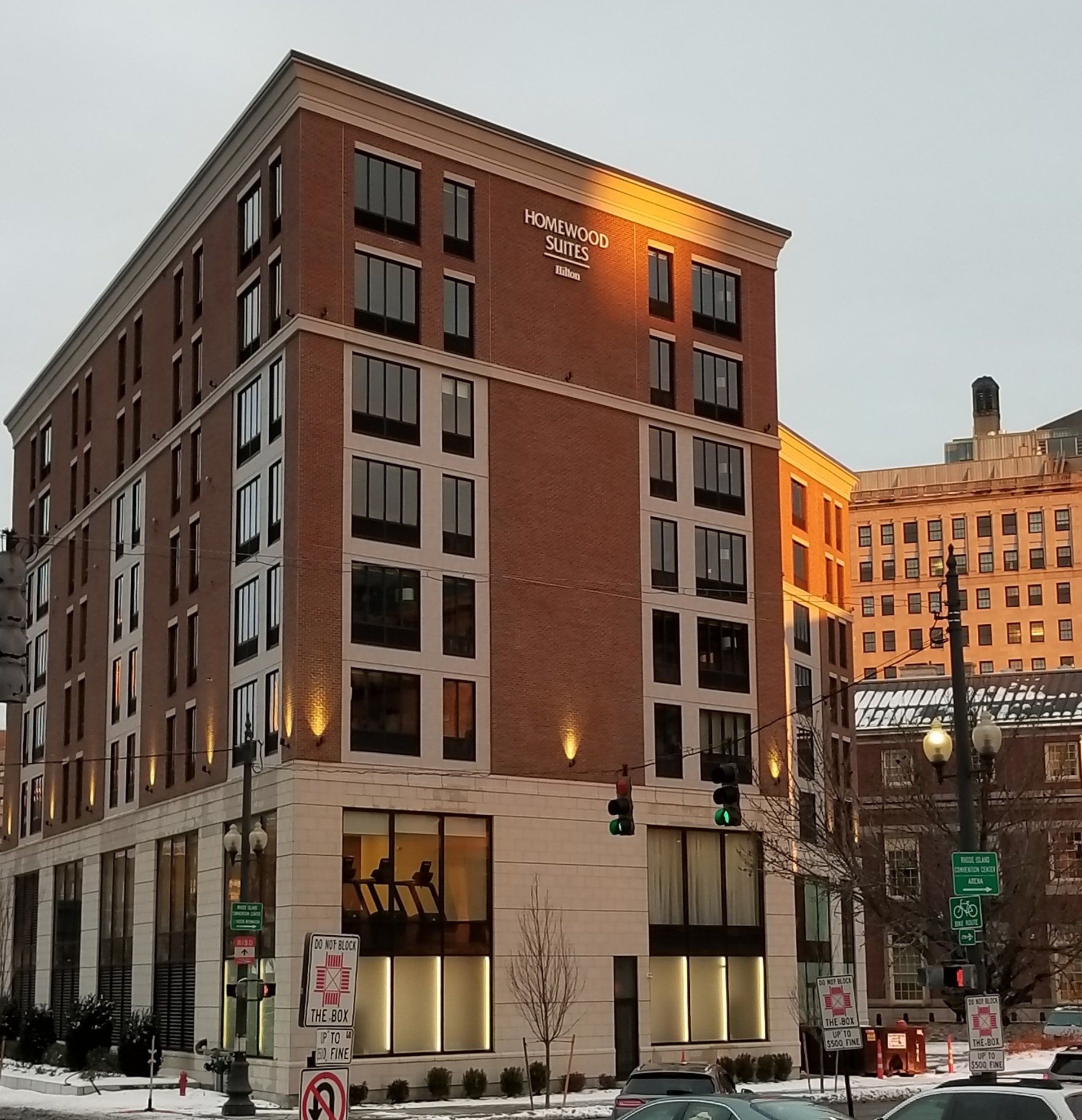 Brick hotel building with several floors and large windows.
