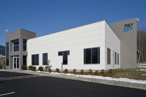 Modern industrial building with white and gray exterior, windows, and 
