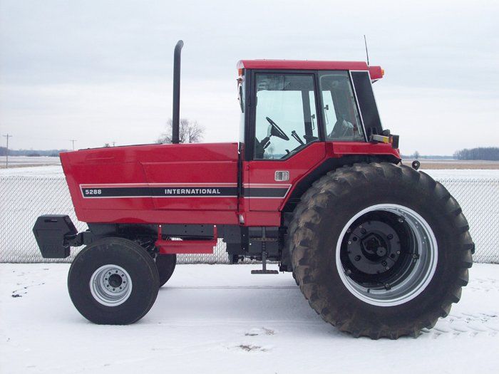 Red Case IH 7150 tractor with large tires on snow.