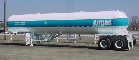 A large, white and blue Airgas tanker truck parked on pavement.