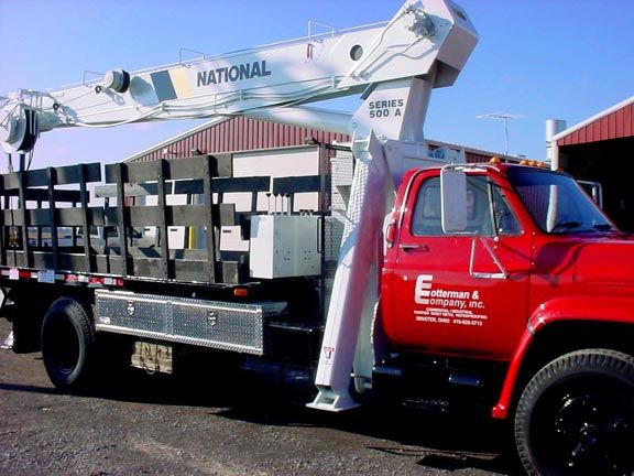 Red truck with white crane lifting equipment.
