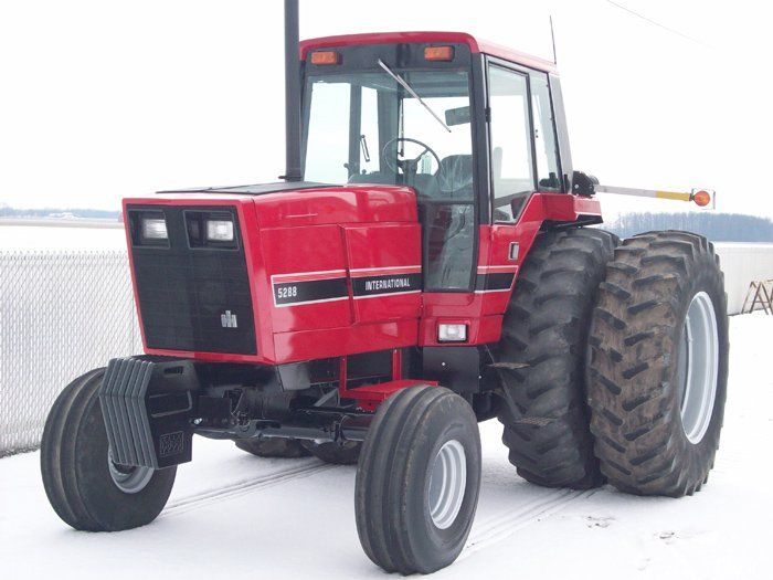 Red International 5288 tractor with dual rear wheels on a snow-covered field.