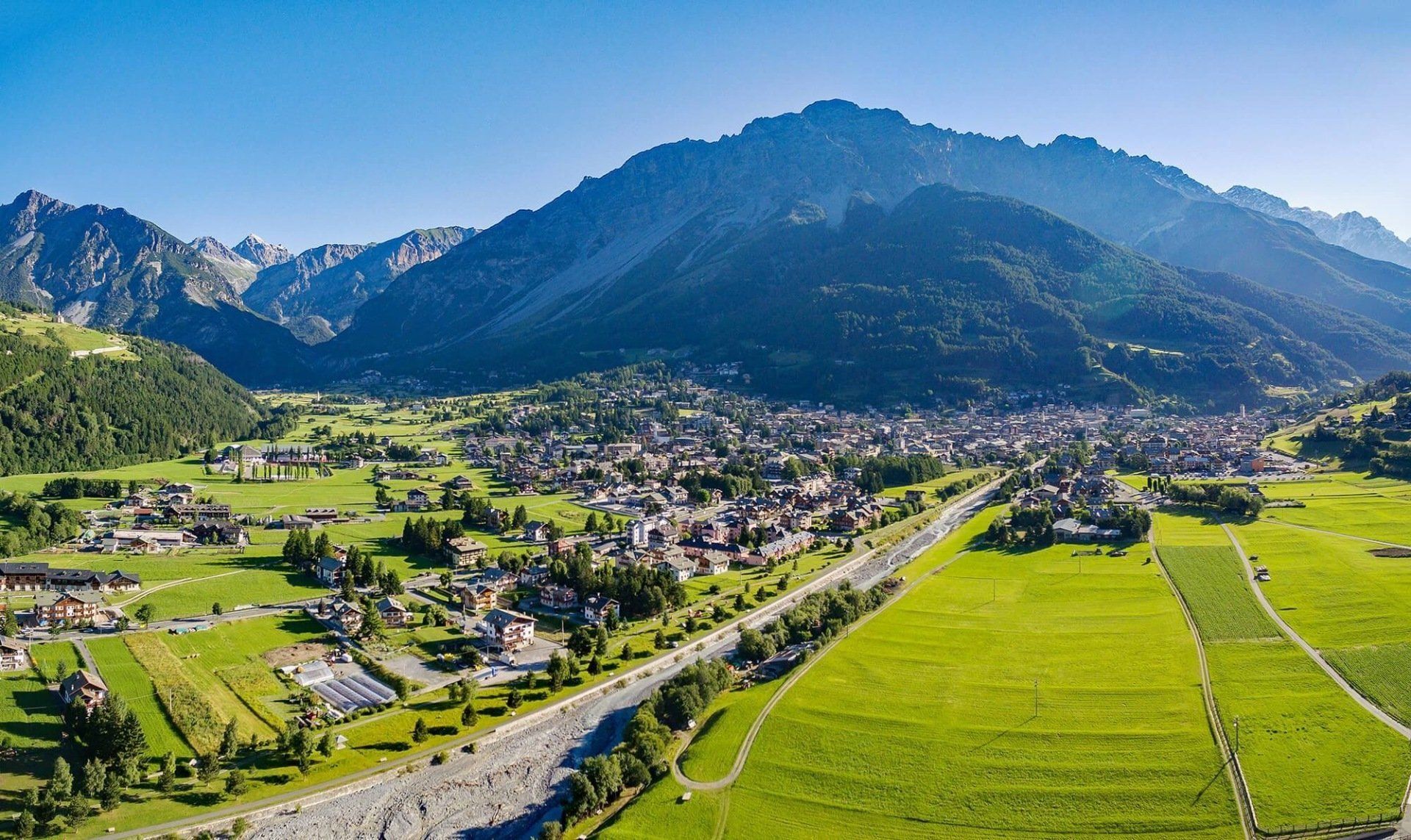Una veduta aerea di una piccola città in montagna attraversata da un fiume.
